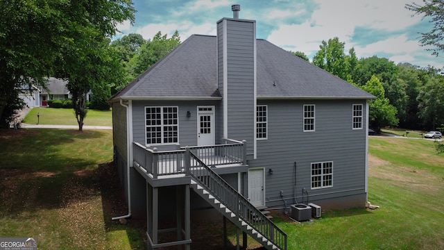 back of property featuring a wooden deck, a yard, and central AC