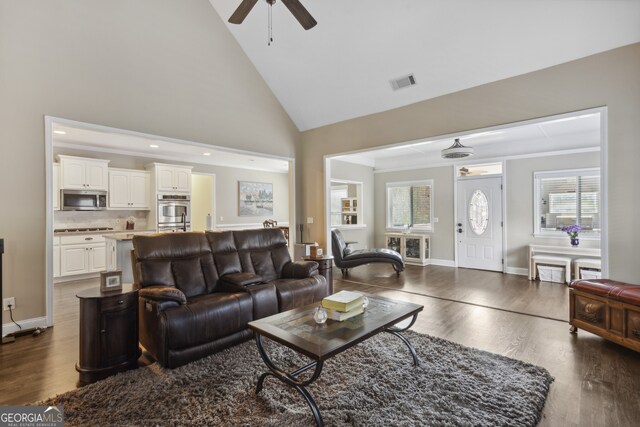 living room with ornamental molding, hardwood / wood-style floors, ceiling fan, and high vaulted ceiling