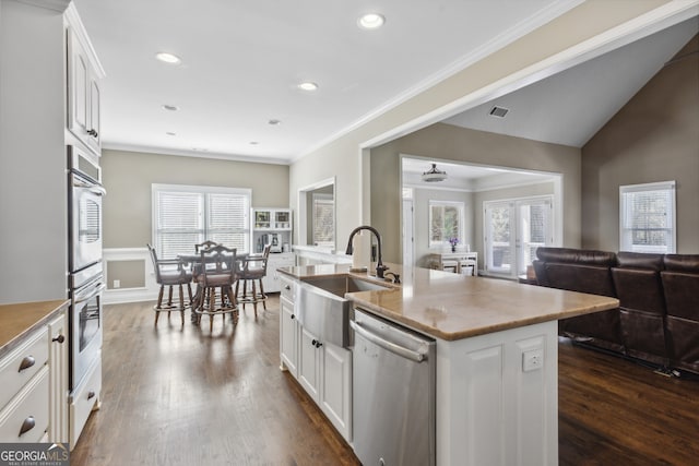 kitchen with appliances with stainless steel finishes, sink, a center island with sink, and white cabinets