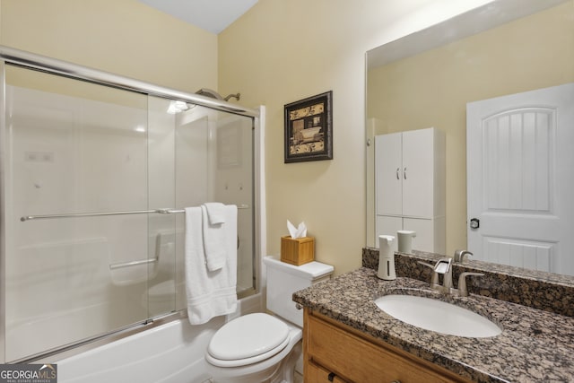 full bathroom featuring vanity, bath / shower combo with glass door, and toilet