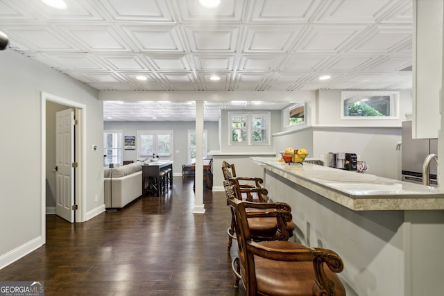 kitchen featuring dark hardwood / wood-style floors, a kitchen breakfast bar, french doors, and ornate columns