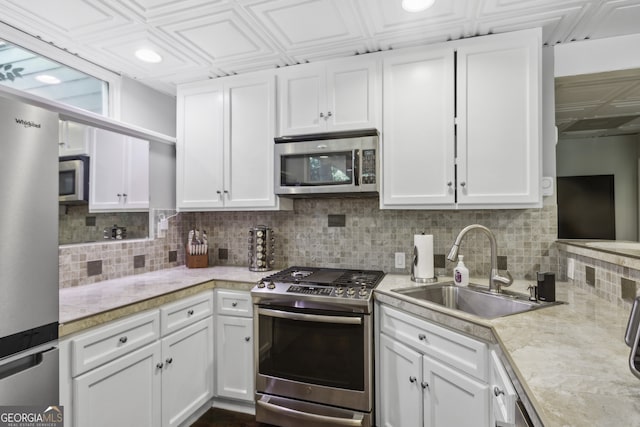 kitchen featuring white cabinetry, sink, decorative backsplash, and stainless steel appliances