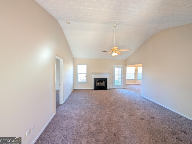 unfurnished living room with a textured ceiling, ceiling fan, carpet, and vaulted ceiling