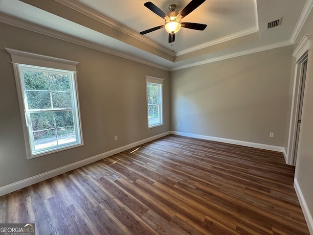 unfurnished bedroom with a tray ceiling, ceiling fan, crown molding, and dark wood-type flooring