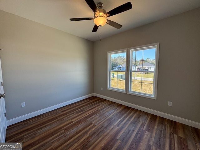 empty room with dark hardwood / wood-style floors and ceiling fan