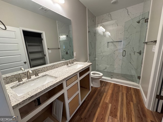 bathroom with vanity, hardwood / wood-style flooring, toilet, and a shower with door