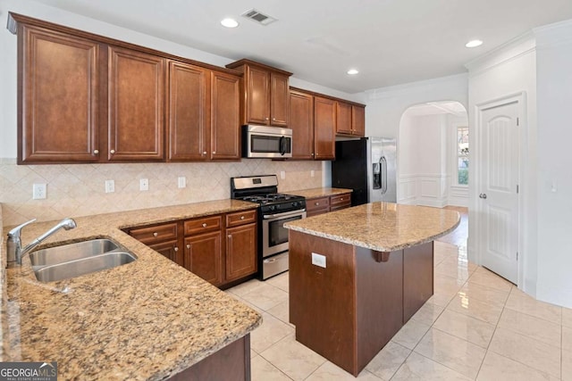 kitchen featuring light stone countertops, appliances with stainless steel finishes, and sink