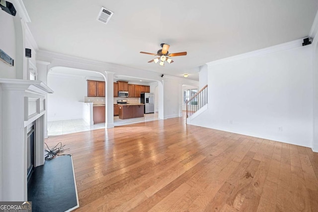 living room with ceiling fan, crown molding, and light wood-type flooring