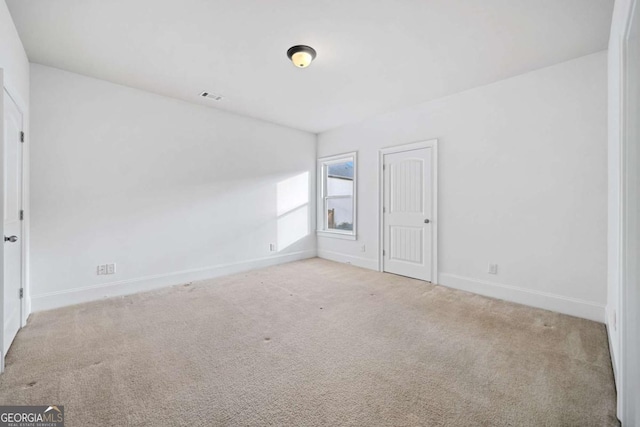 spare room featuring light carpet