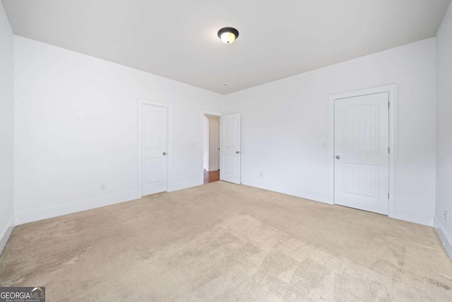 spare room featuring light colored carpet