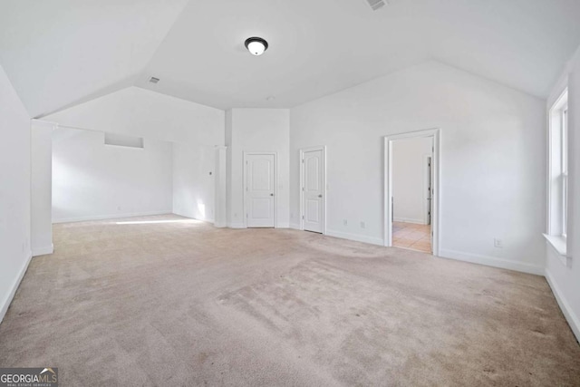 bonus room with light colored carpet and lofted ceiling