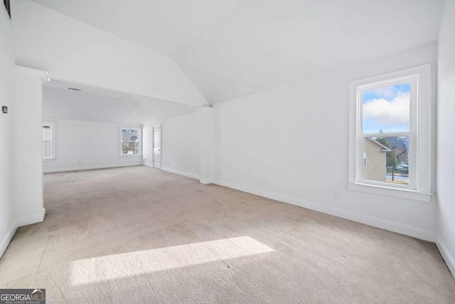 interior space with light colored carpet and lofted ceiling