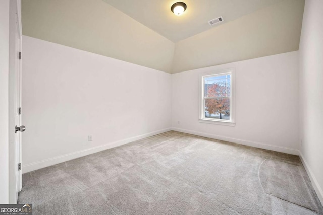 carpeted empty room featuring lofted ceiling