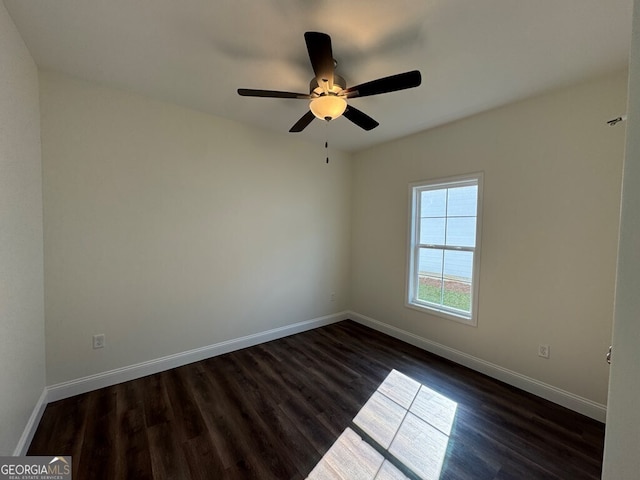 spare room featuring dark hardwood / wood-style flooring and ceiling fan