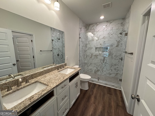 bathroom featuring vanity, hardwood / wood-style flooring, toilet, and a shower with shower door