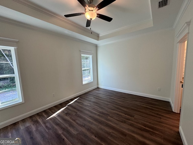 spare room with dark hardwood / wood-style flooring, a tray ceiling, ceiling fan, and ornamental molding