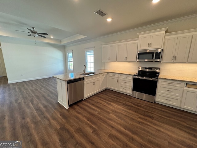 kitchen featuring white cabinetry, ceiling fan, stainless steel appliances, dark hardwood / wood-style floors, and kitchen peninsula