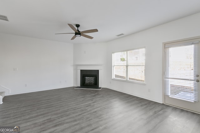 unfurnished living room with dark hardwood / wood-style floors, plenty of natural light, and ceiling fan