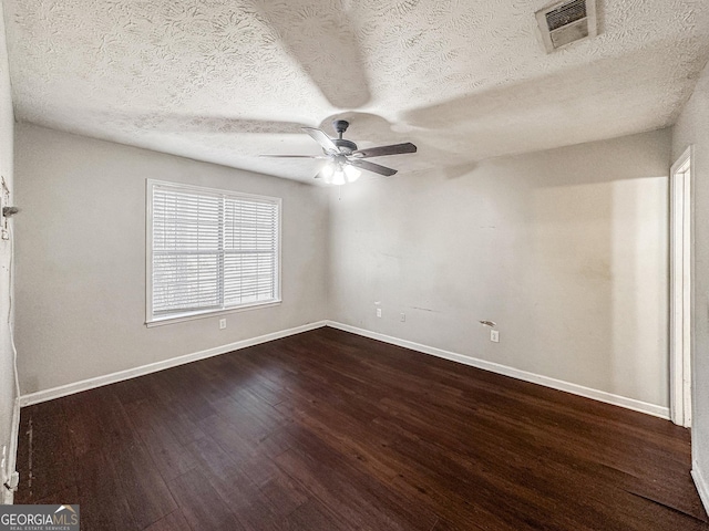 empty room with a textured ceiling, dark hardwood / wood-style floors, and ceiling fan