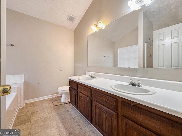 bathroom featuring a tub, a textured ceiling, lofted ceiling, toilet, and vanity