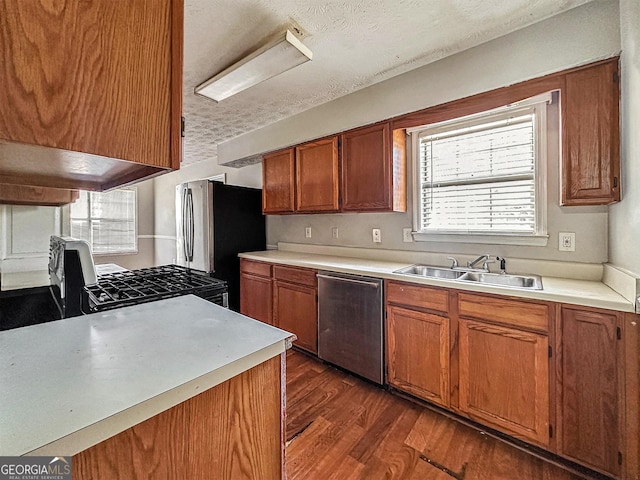 kitchen with sink, dark wood-type flooring, a textured ceiling, and appliances with stainless steel finishes