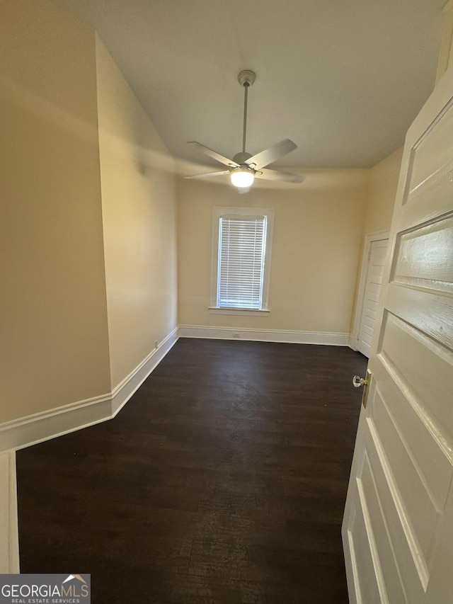 empty room with ceiling fan and dark hardwood / wood-style flooring