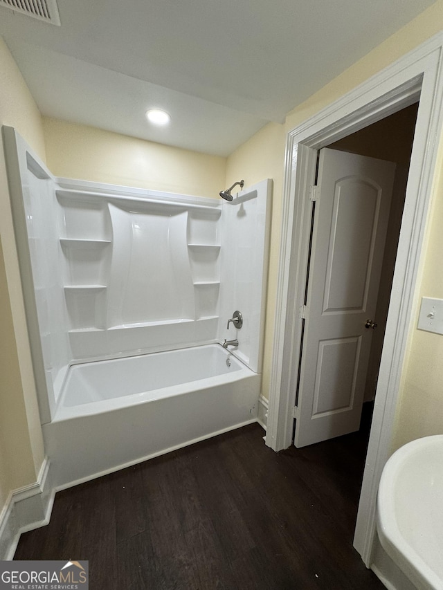 bathroom with bathing tub / shower combination and hardwood / wood-style flooring