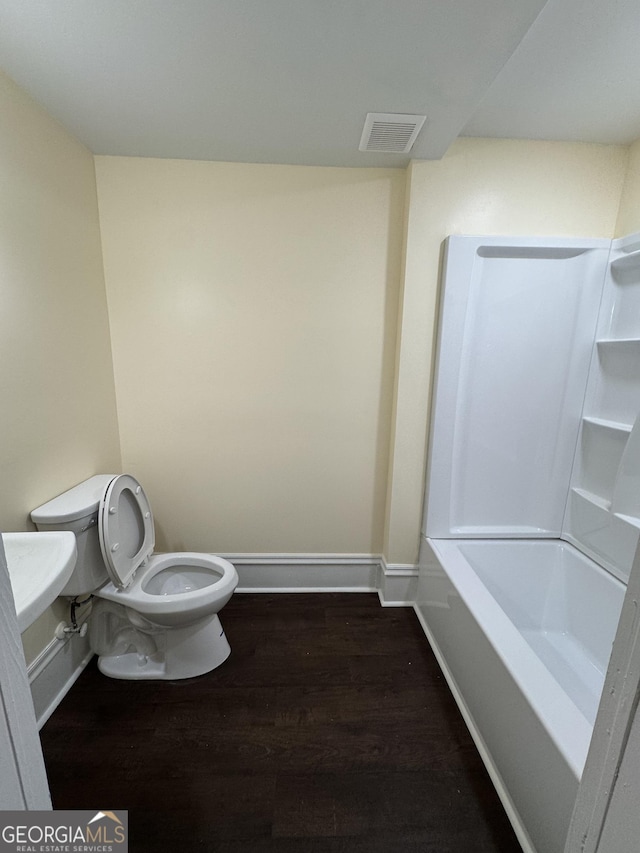 bathroom with hardwood / wood-style floors and toilet