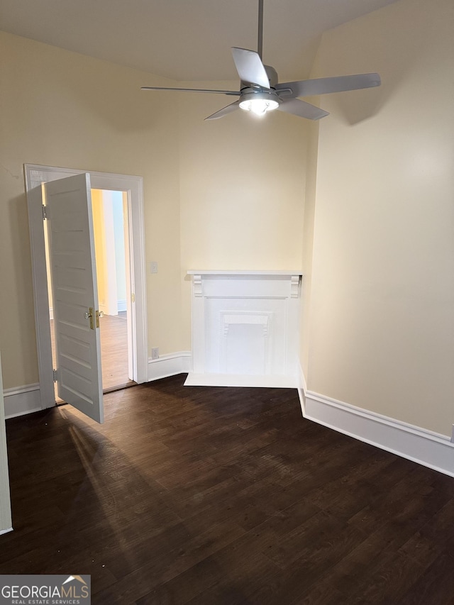 unfurnished living room with dark hardwood / wood-style flooring and ceiling fan