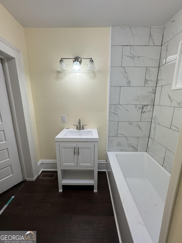 bathroom featuring a washtub, vanity, and hardwood / wood-style flooring