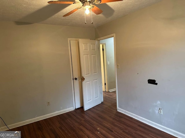 spare room featuring ceiling fan, dark hardwood / wood-style floors, and a textured ceiling