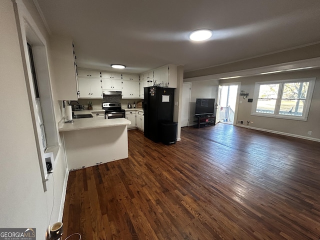 kitchen featuring stainless steel electric range, white cabinets, sink, black fridge, and kitchen peninsula