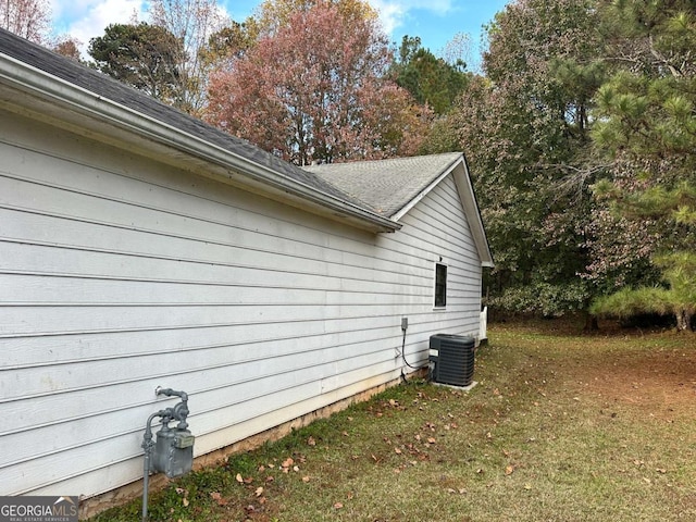 view of side of home featuring a lawn and central air condition unit