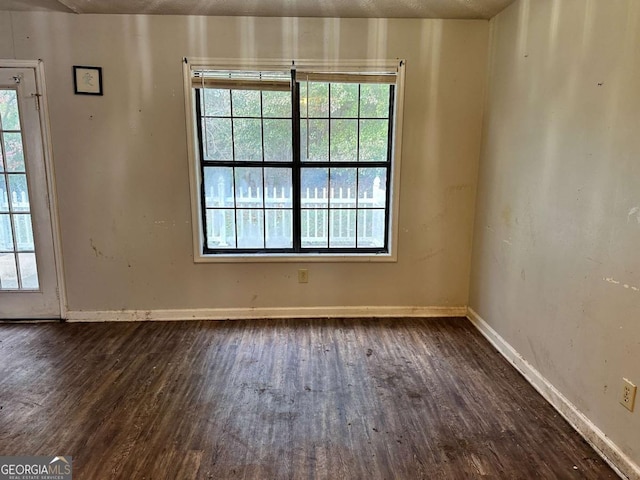 empty room featuring dark hardwood / wood-style flooring and a textured ceiling