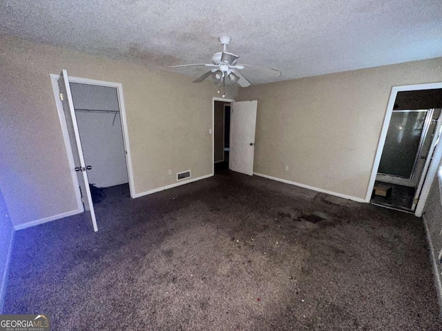 unfurnished bedroom with ceiling fan, a closet, a textured ceiling, and dark colored carpet