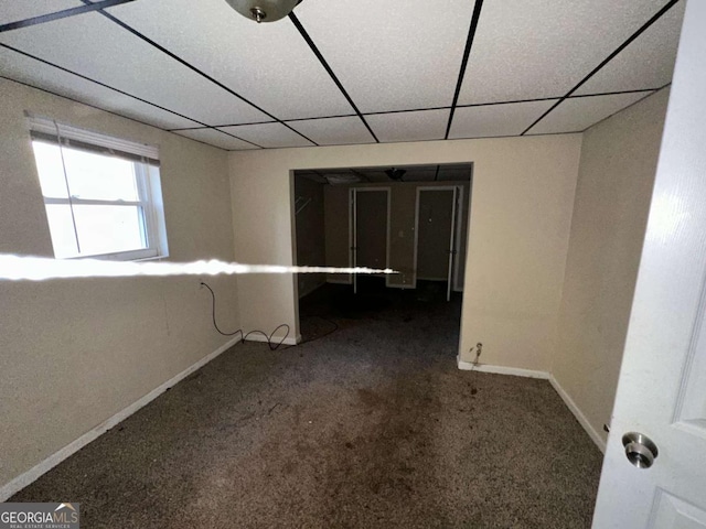 empty room with carpet and a paneled ceiling