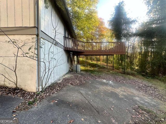 view of side of property with central AC unit and a deck