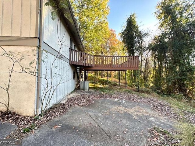 view of property exterior with a wooden deck and a patio