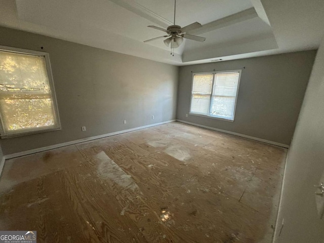 spare room with a raised ceiling and ceiling fan