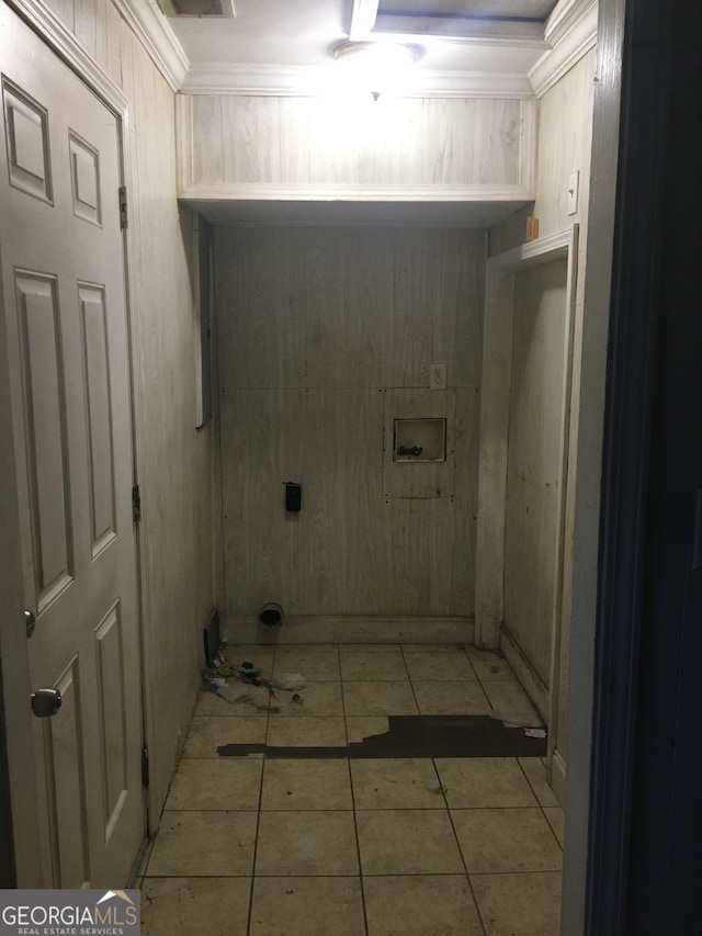 washroom with wood walls, light tile patterned floors, ornamental molding, and hookup for a washing machine