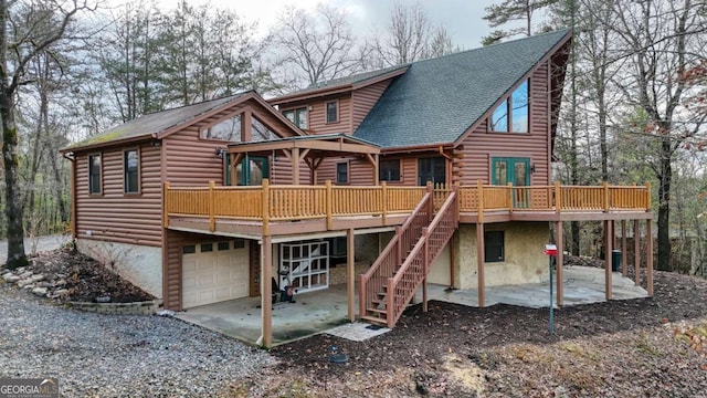 back of house featuring a garage, a patio, and a wooden deck