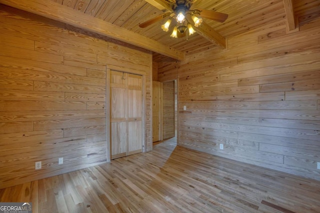 spare room with wood walls, ceiling fan, light hardwood / wood-style floors, beam ceiling, and wood ceiling