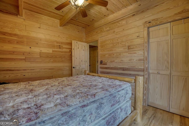 bedroom featuring wood ceiling, ceiling fan, wooden walls, beam ceiling, and light hardwood / wood-style floors