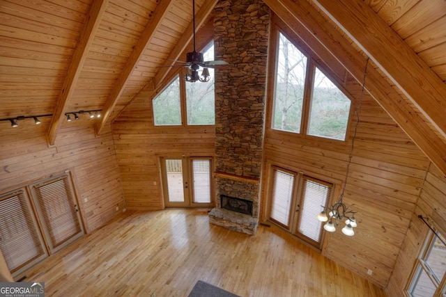 unfurnished living room featuring wooden ceiling, light wood-type flooring, high vaulted ceiling, and french doors