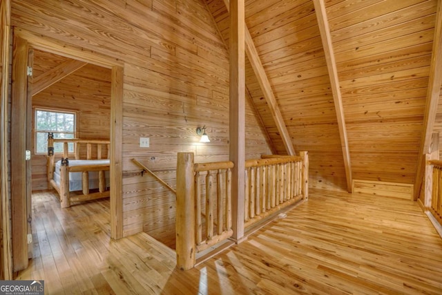 bonus room with hardwood / wood-style floors, lofted ceiling with beams, wood ceiling, and wooden walls