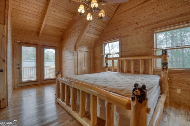 bedroom with light wood-type flooring, multiple windows, and wood walls