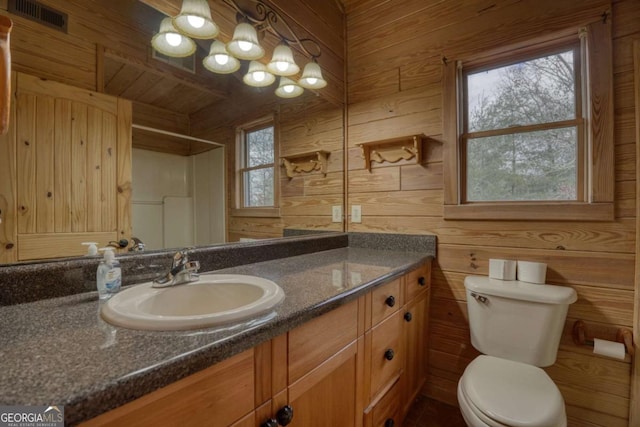 bathroom featuring vanity, toilet, walk in shower, and wooden walls