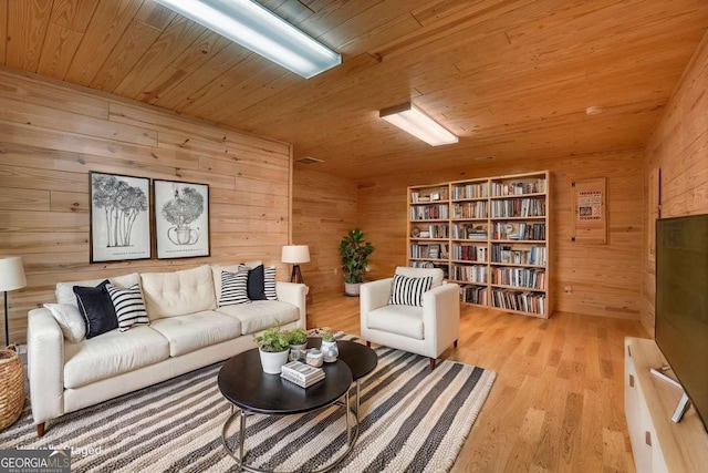 living room with light hardwood / wood-style flooring, wooden walls, and wood ceiling