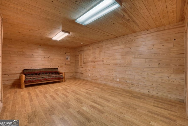 sitting room featuring wood walls, light wood-type flooring, and wood ceiling