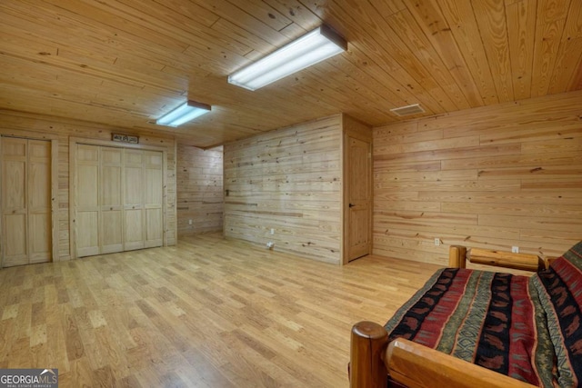 unfurnished bedroom with wood ceiling, wooden walls, and light hardwood / wood-style floors